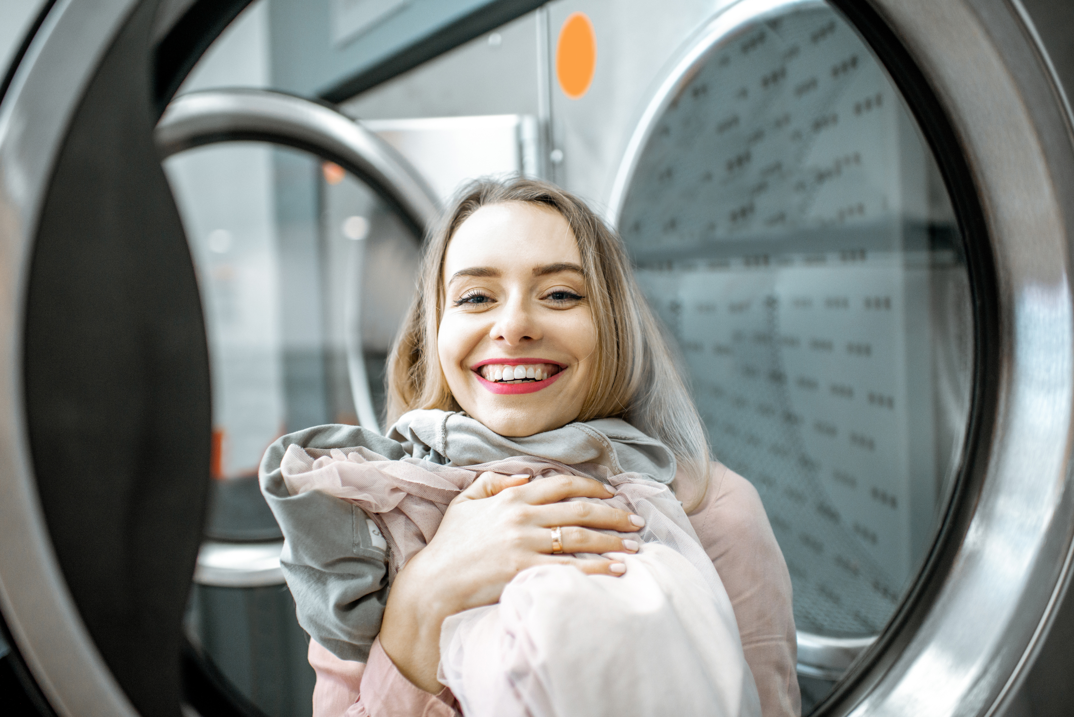 POV of a smiling woman removing a blanket from a dryer